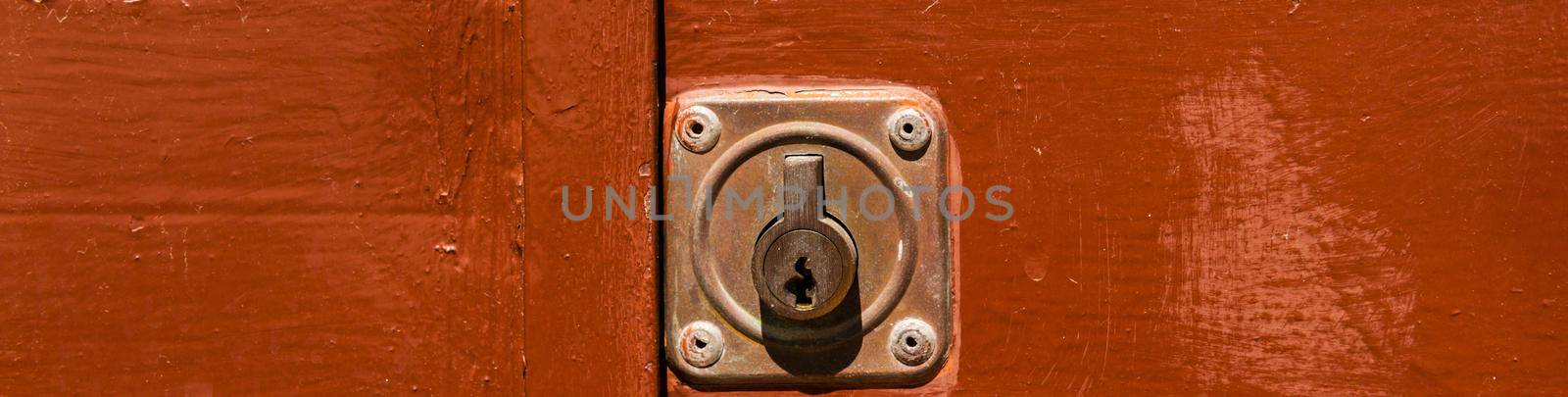 close up on the old lock with an interesting texture on the door, home security by Q77photo