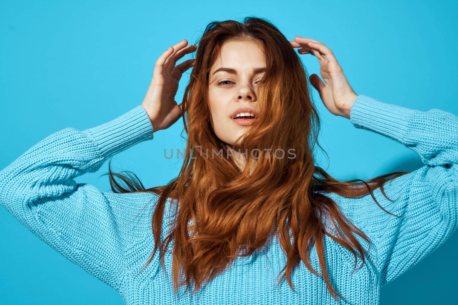 pretty woman in a blue sweater blue background Lifestyle. High quality photo