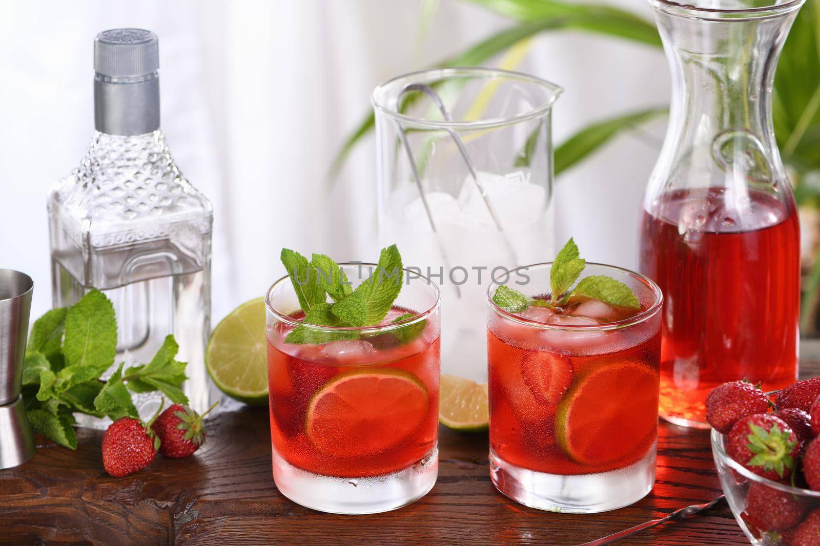 Refreshing cocktail strawberry mojito with ice, fresh mint and lime. A great idea for a picnic or summer party. It may contain alcohol or be a mocktail.