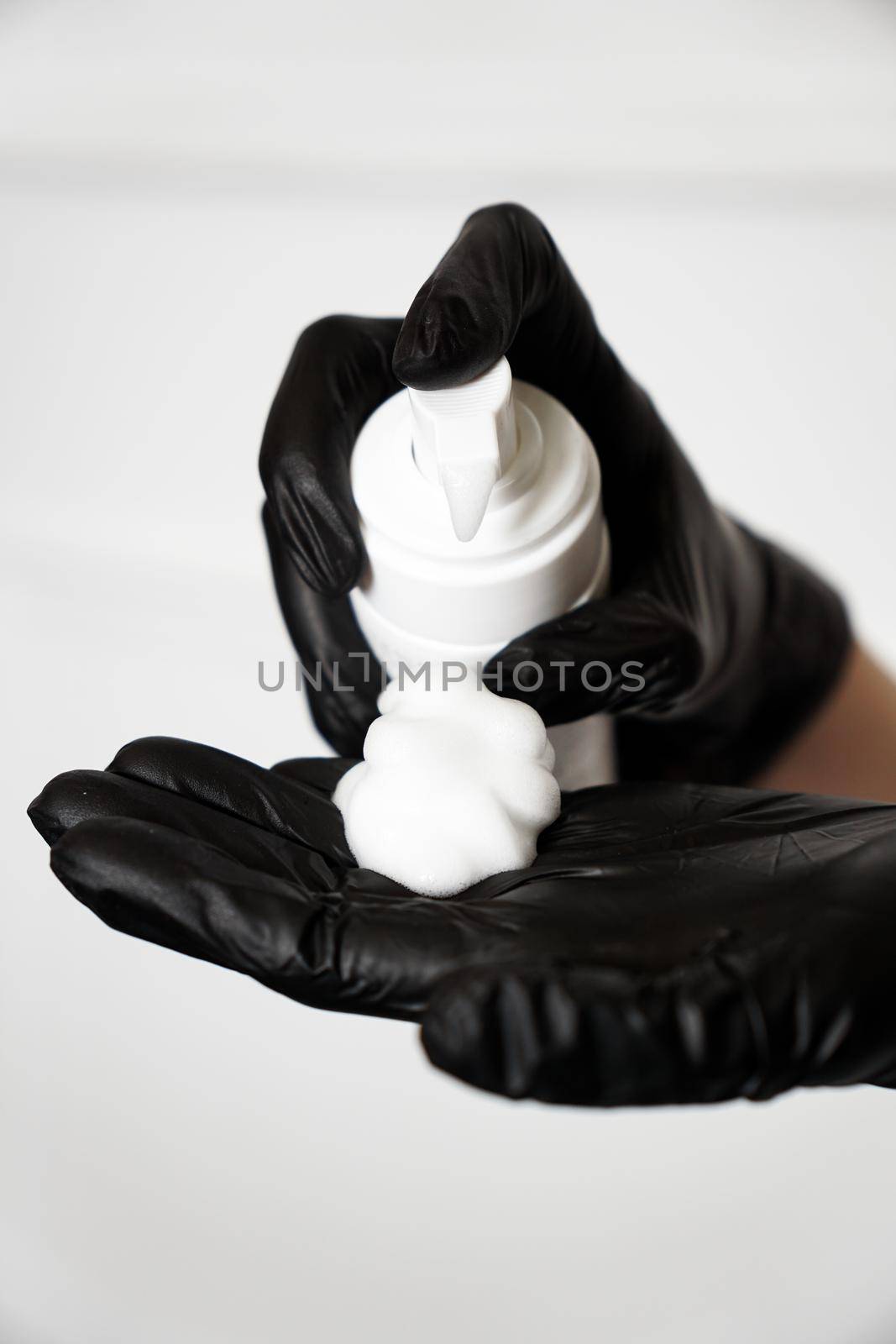 Closeup of a female hand with foam on the palm in black gloves by natali_brill