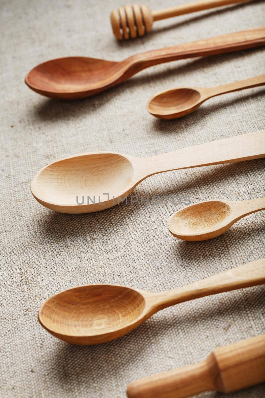 Wooden spoons made of natural wood on burlap fabric as a craft. by AlexGrec