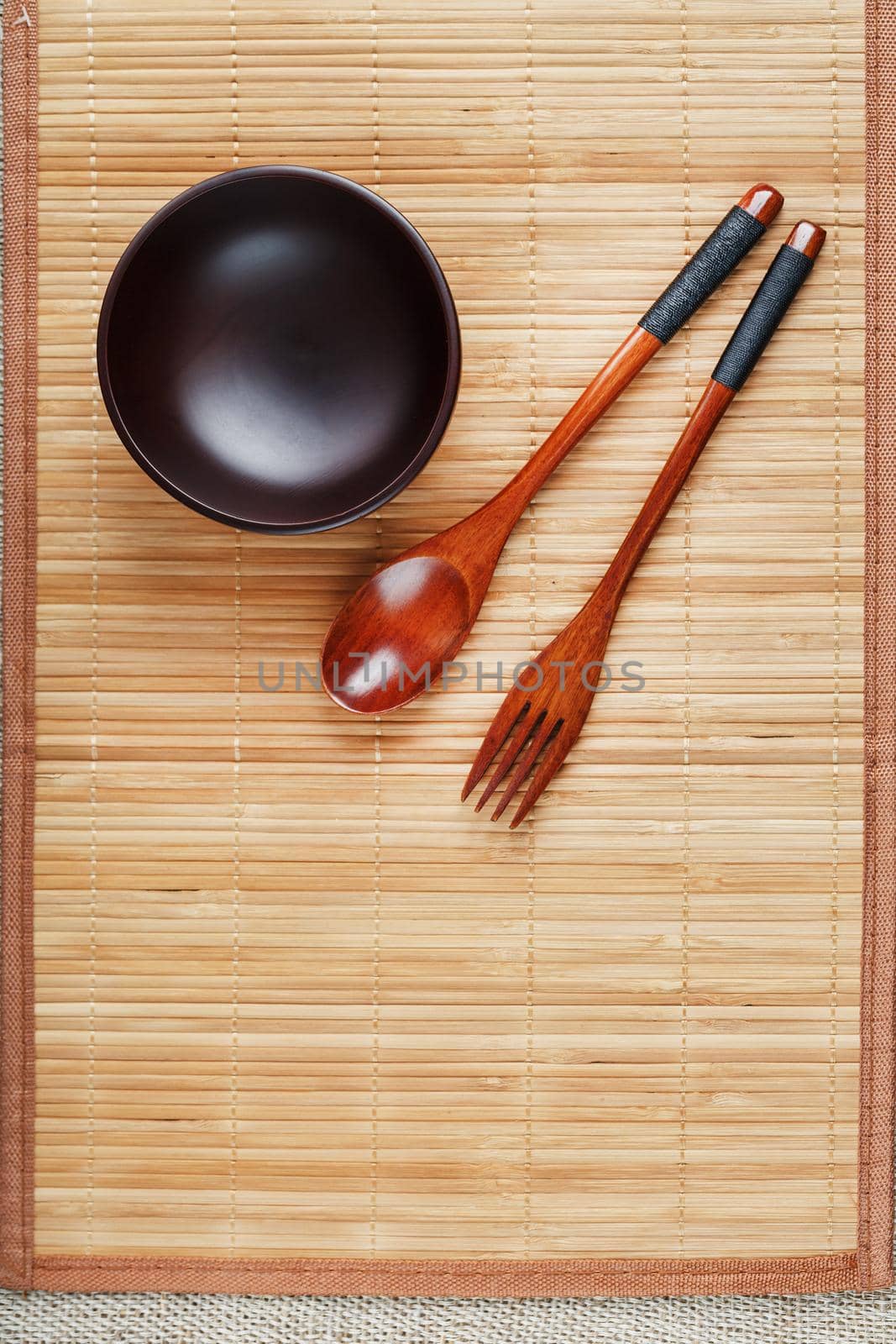 Utensils made of wood, bowl and spoons on a cutting board on a white background by AlexGrec