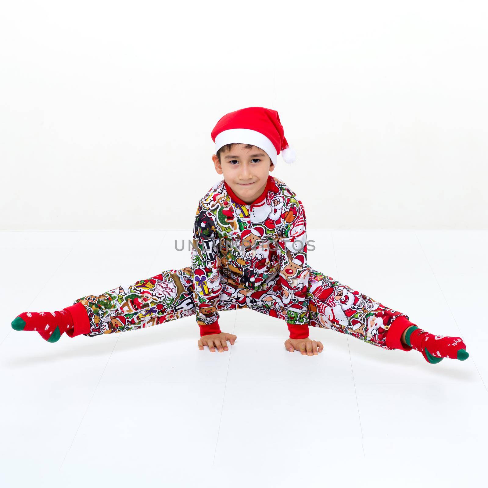 Boy in Christmas outfit doing a handstand and splits by kolesnikov_studio