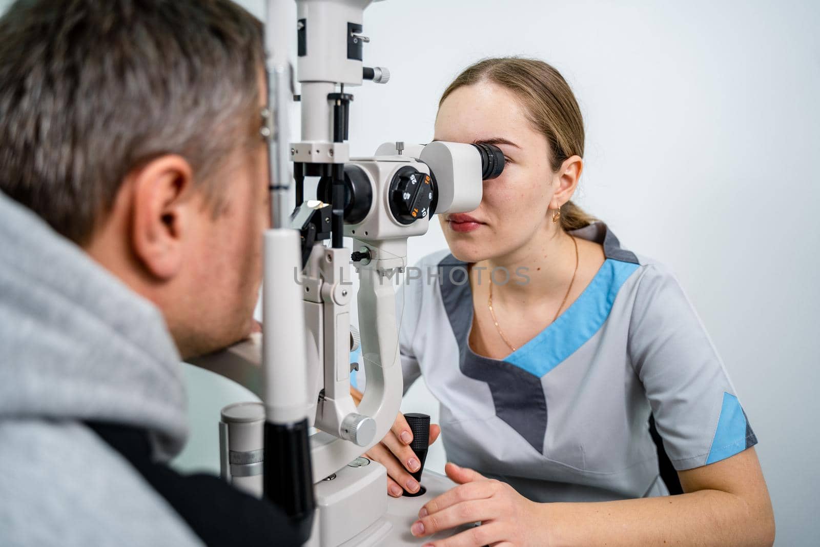 Optometrist examining the eyes of a male patient in a modern ophthalmology clinic. Eye doctor with man patient during an examination in modern clinic. Optometry concept. Eyesight exam in clinic.