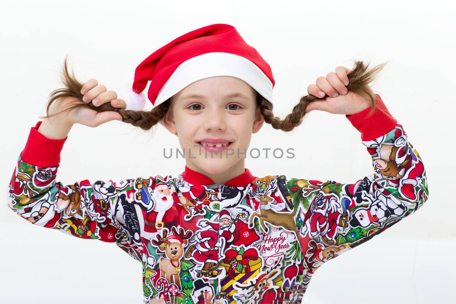 Happy young girl with pigtails and Santa cap by kolesnikov_studio