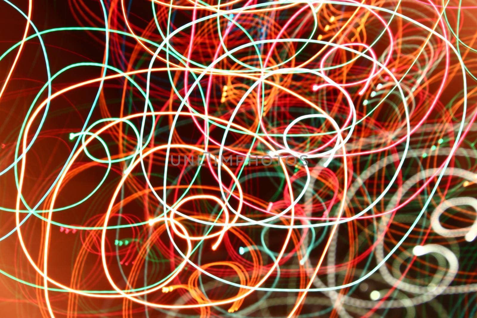 abstract color swirl garland lights. Blurred glowing on dark background by dreamloud