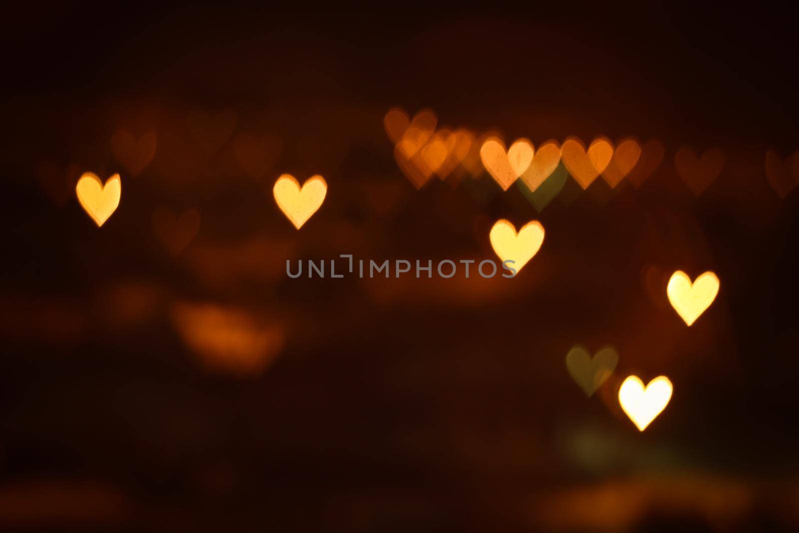 Heart shape bokeh lights on dark background. City lights defocused