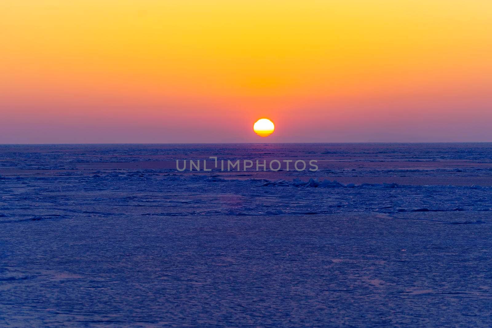 Beautiful sunset over the icy surface of the sea. by Vvicca
