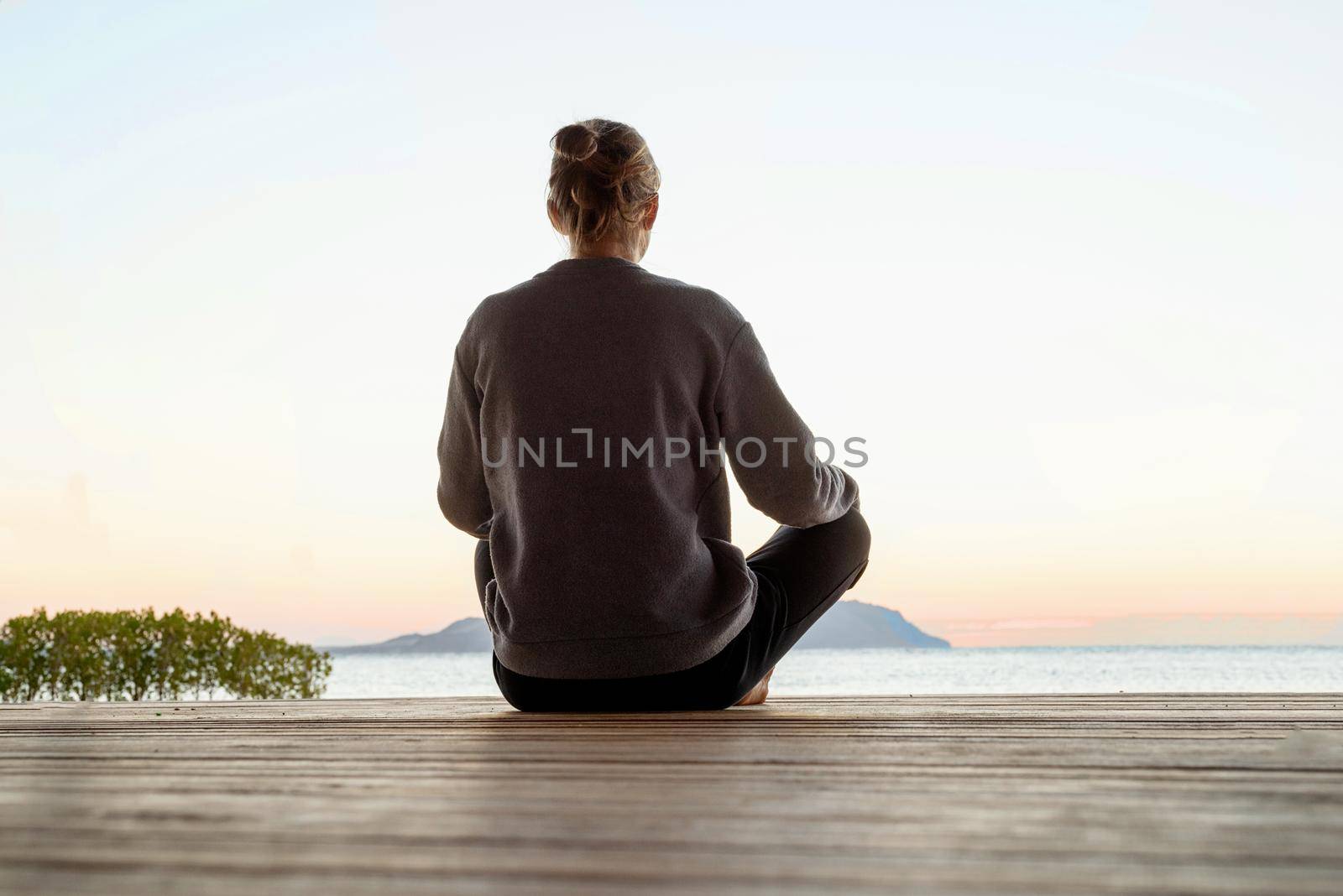 Health and wellness. Young healthy woman practicing yoga and meditation on the beach at sunset