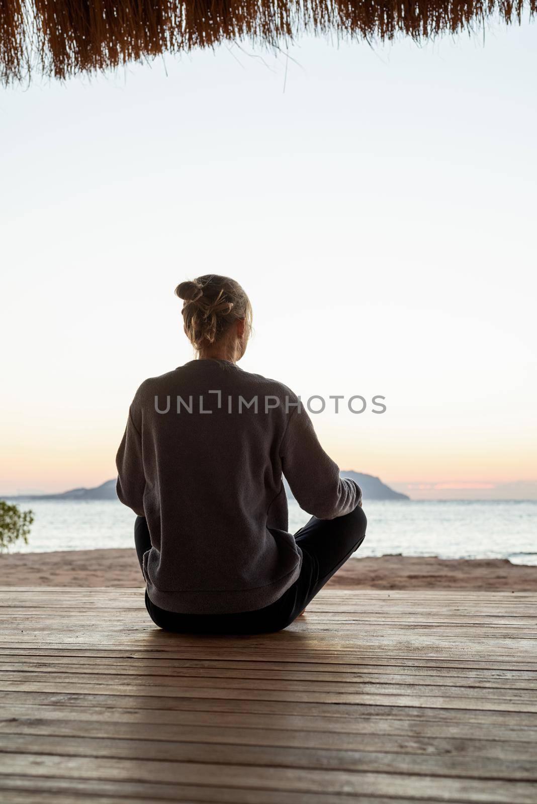 Health and wellness. Young healthy woman practicing yoga and meditation on the beach at sunset