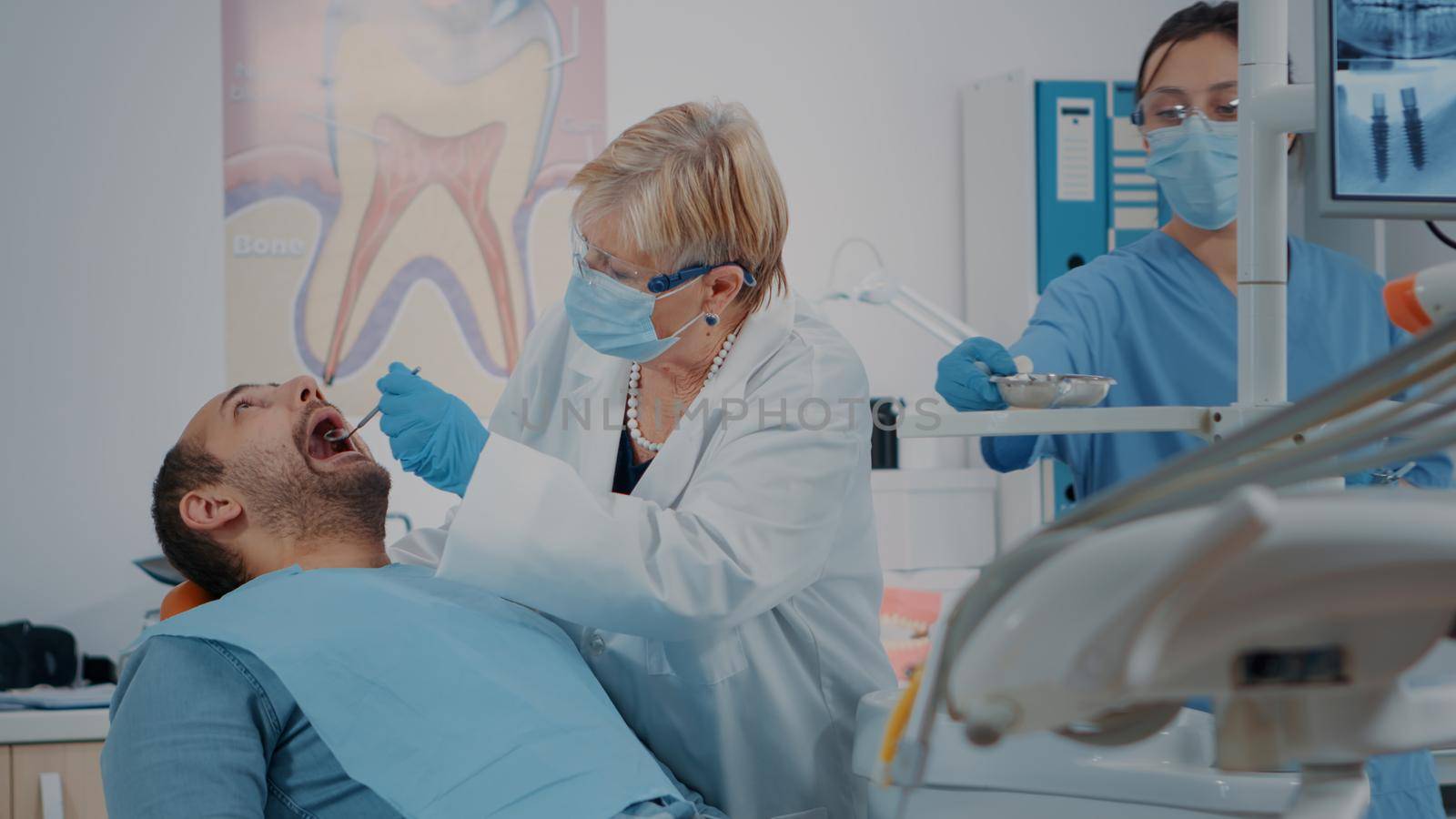 Oral care medic using dental tools to do teeth examination by DCStudio