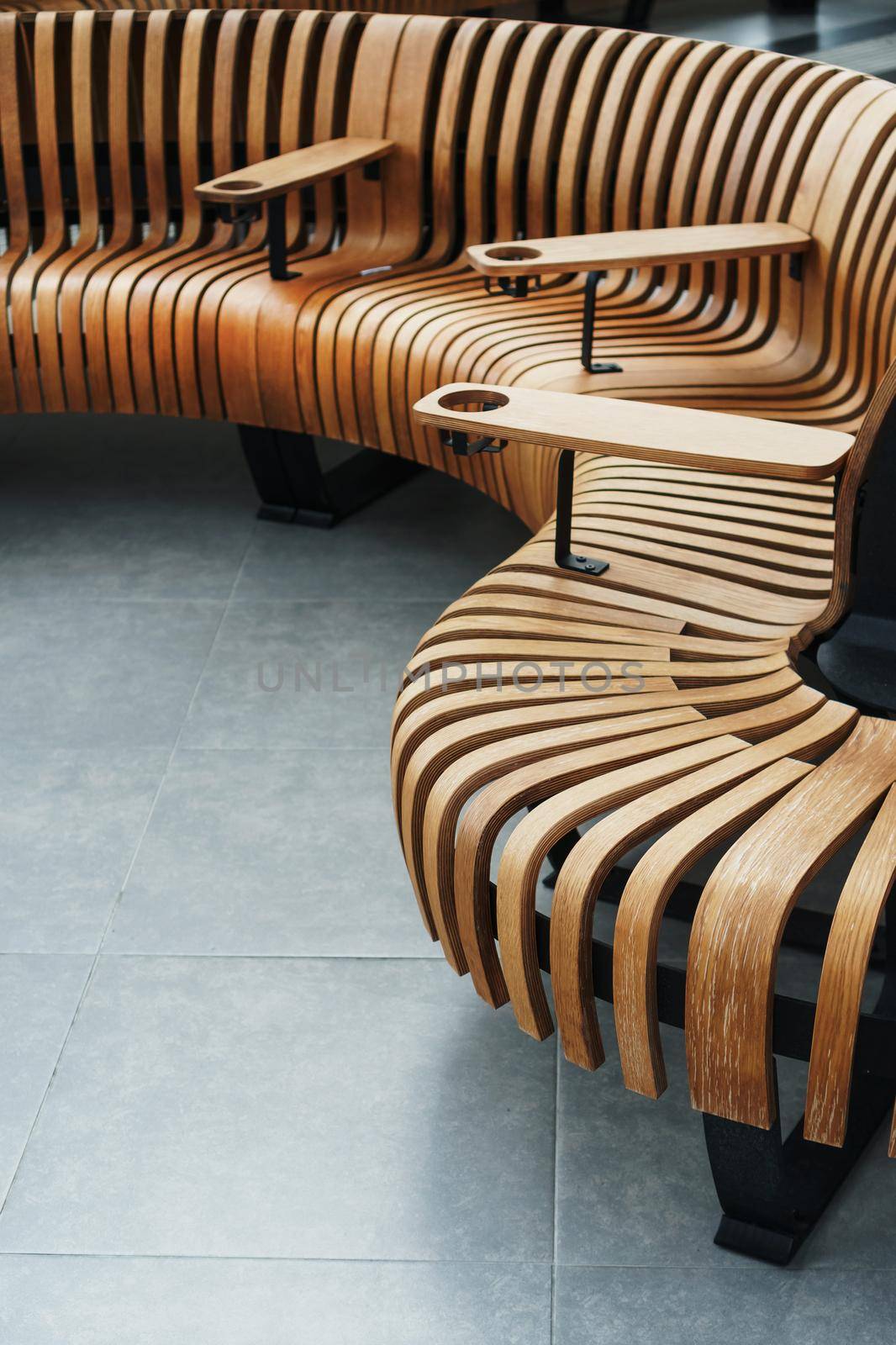Modern curved wooden bench at the airport. Modern interior