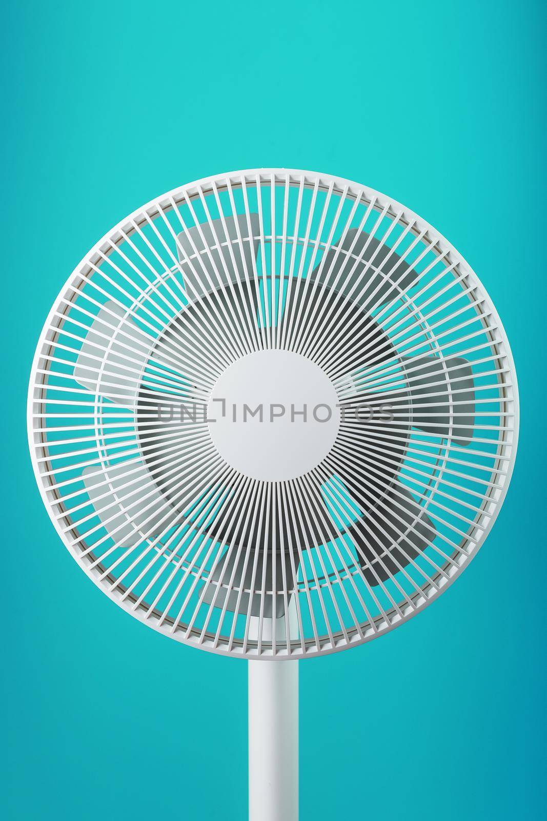 A high-tech white electric fan with a modern design for cooling the room on a blue background by AlexGrec