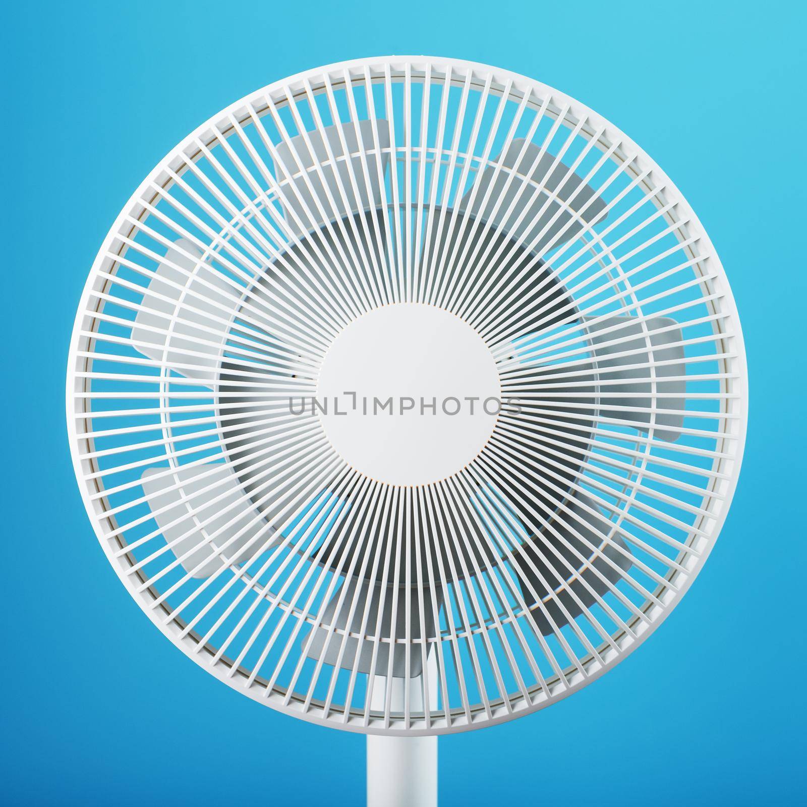 A high-tech white electric fan with a modern design for cooling the room on a blue background. Minimalistic style