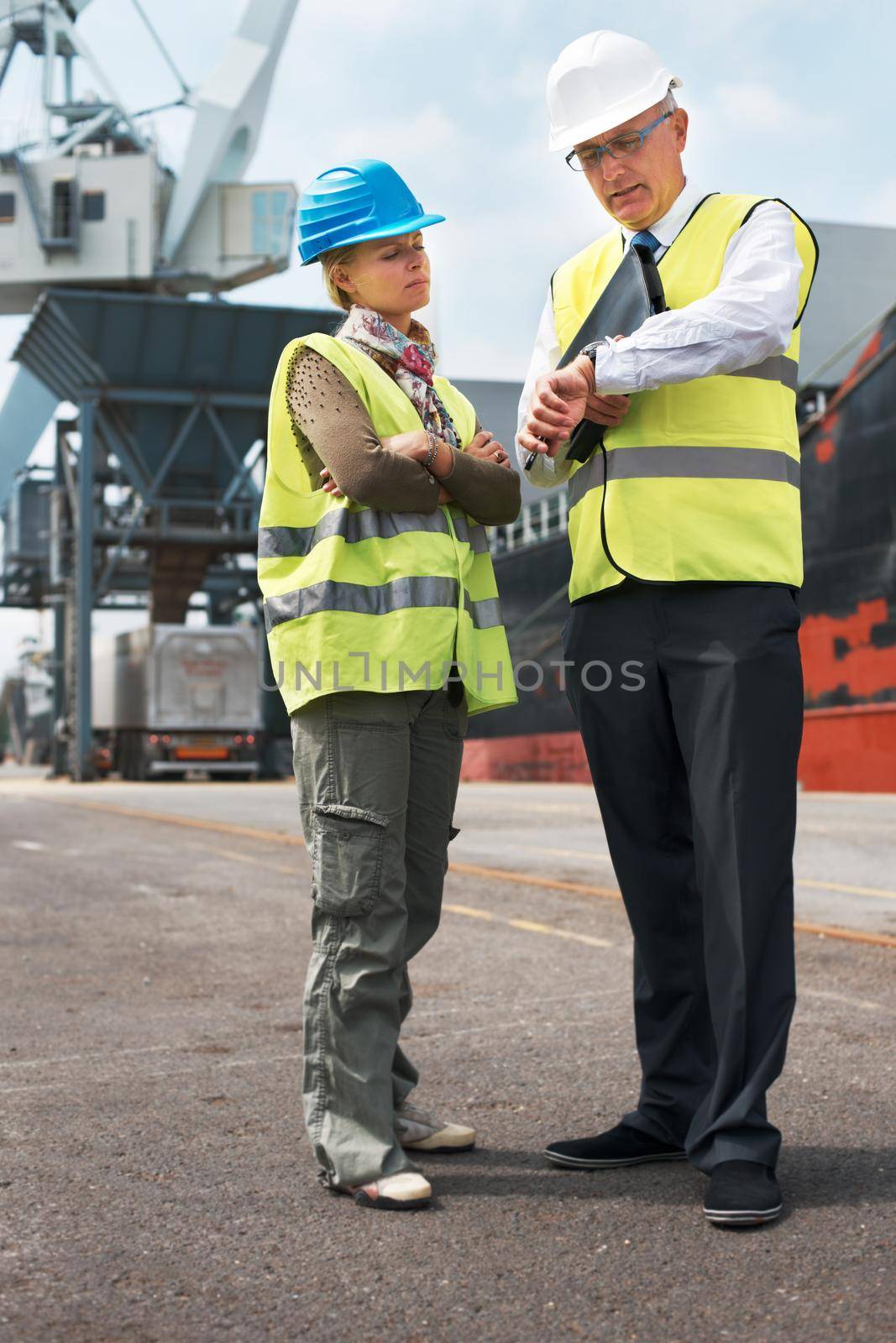 Time is of the essence.. Two engineers discussing planning on a site while in the shipyard. by YuriArcurs