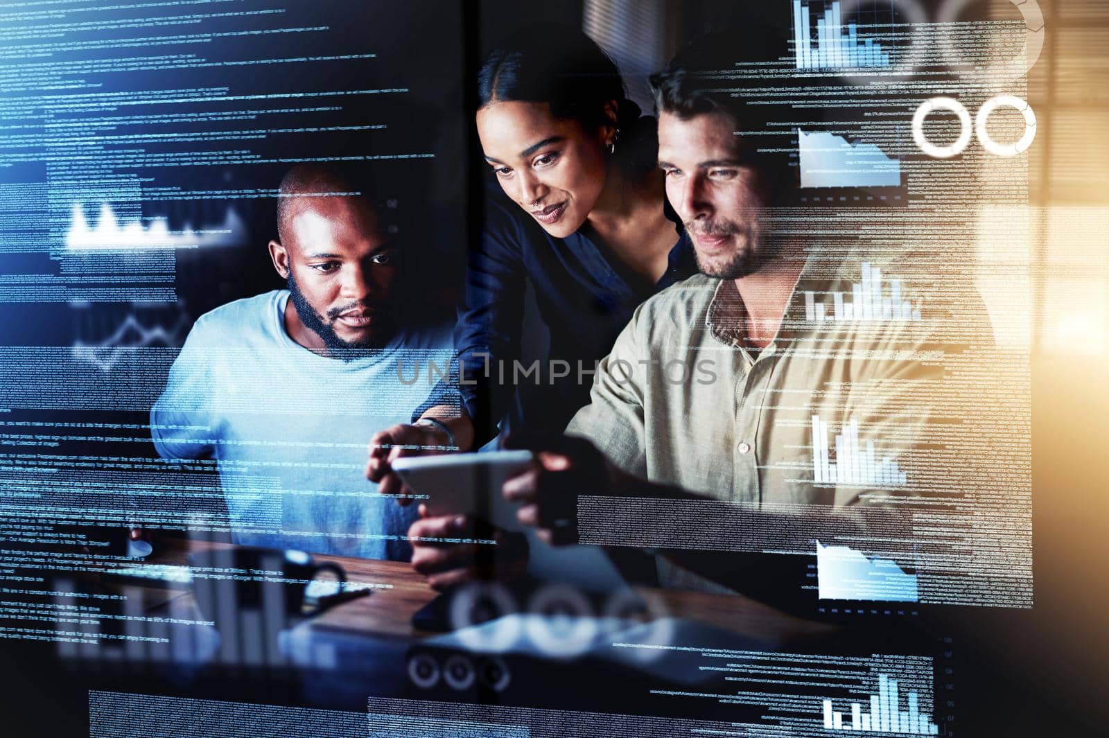 Diving into new networks. Shot of a group of programmers using a digital tablet while working together on a computer code at night. by YuriArcurs