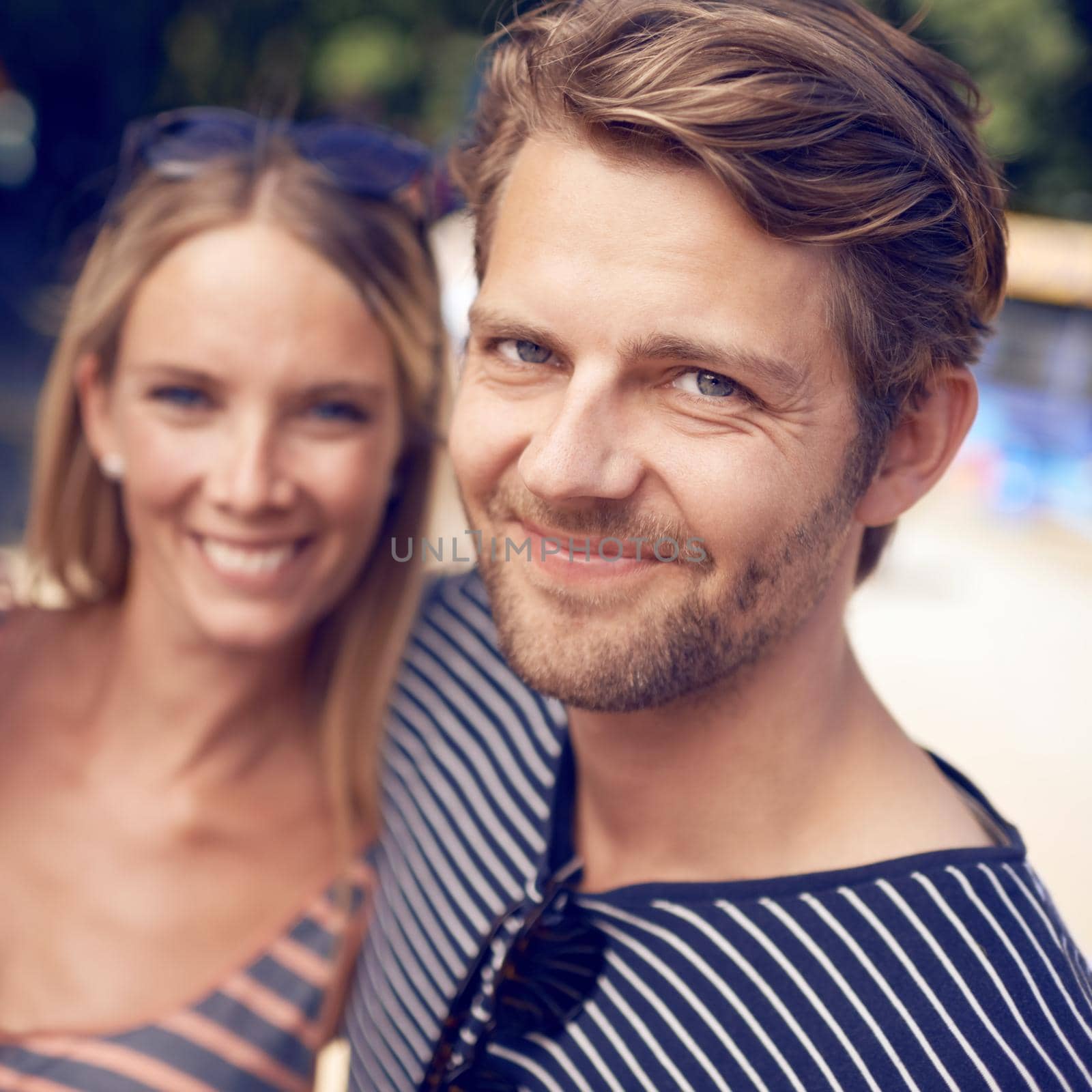 Happy together. Portrait of an attractive couple standing together and smiling. by YuriArcurs