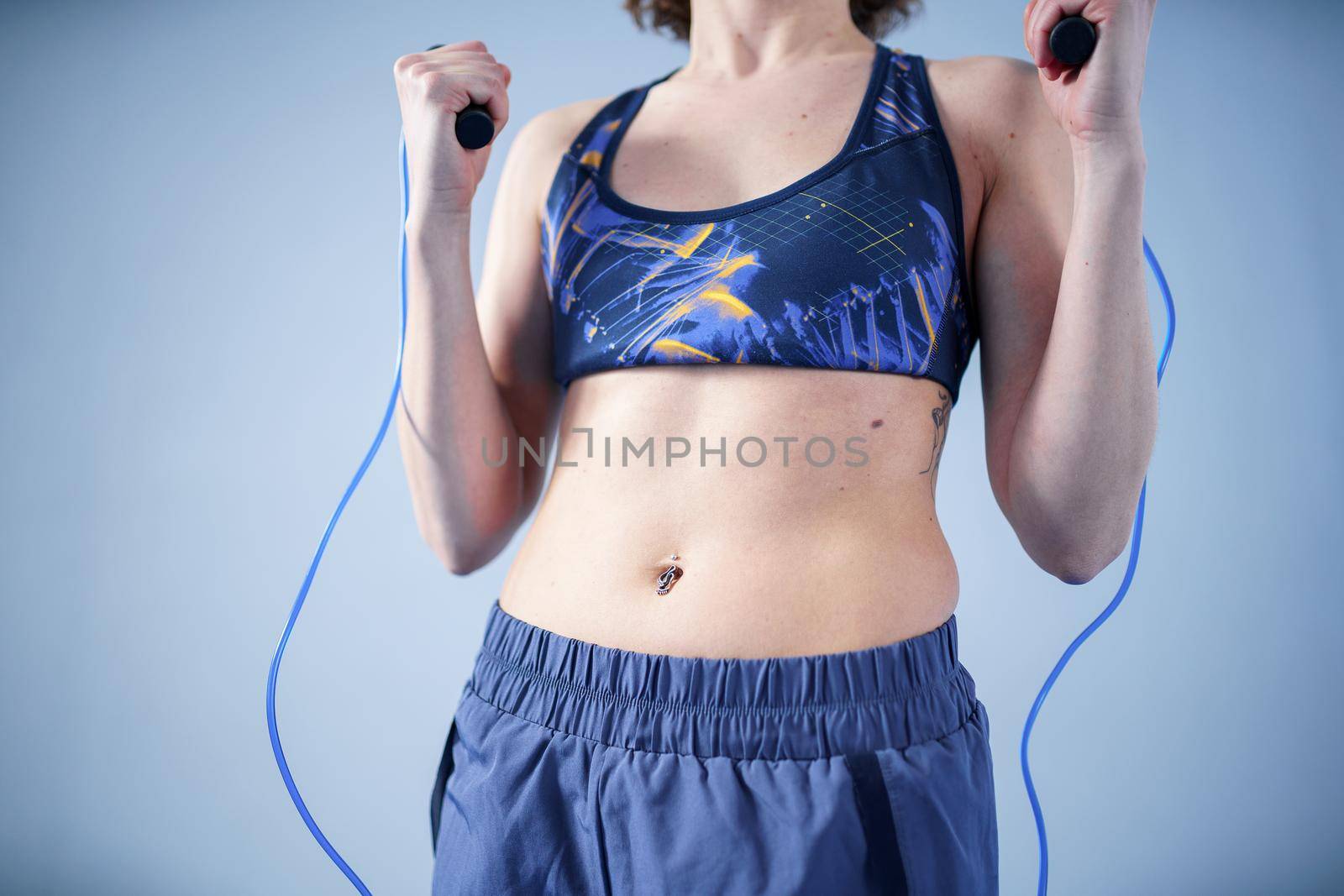 Smiling sportswoman posing with a skipping rope. Female with muscular body posing with jump rope. Fitness model. Body positivity, sport, fitness concept. Healthy lifestyle. Fit woman with jump rope.