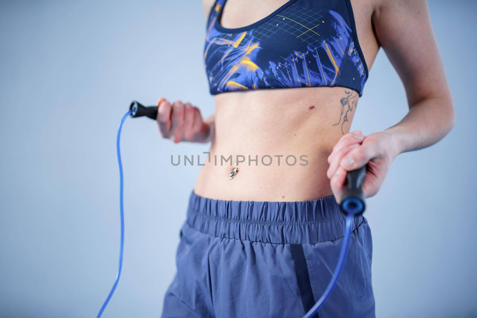 Fit woman with jump rope posing in the gym. Sport exercises healthy lifestyle concept. Sporty happy woman with skipping rope posing to the camera. Active lifestyle concept. Healthy lifestyle by Tomashevska