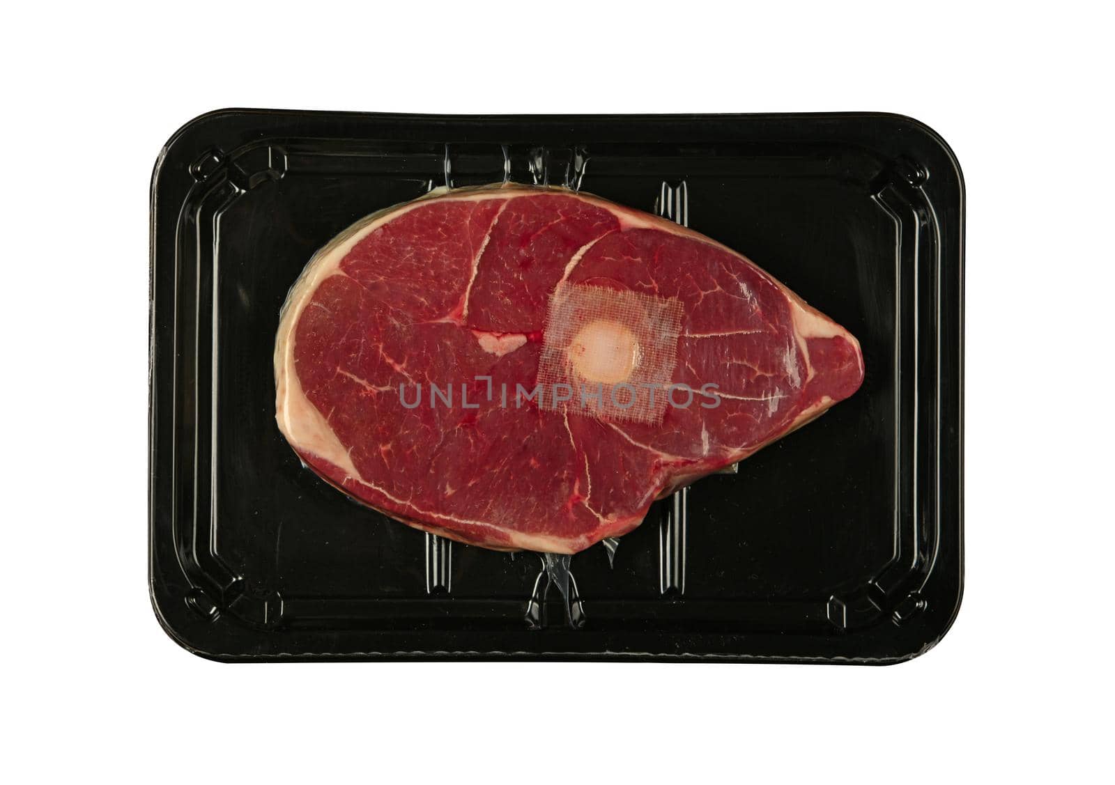 Close up raw lamb or mutton meat ossobuco or osso buco shank vacuum sealed with black plastic film , isolated on white background, elevated top view, directly above