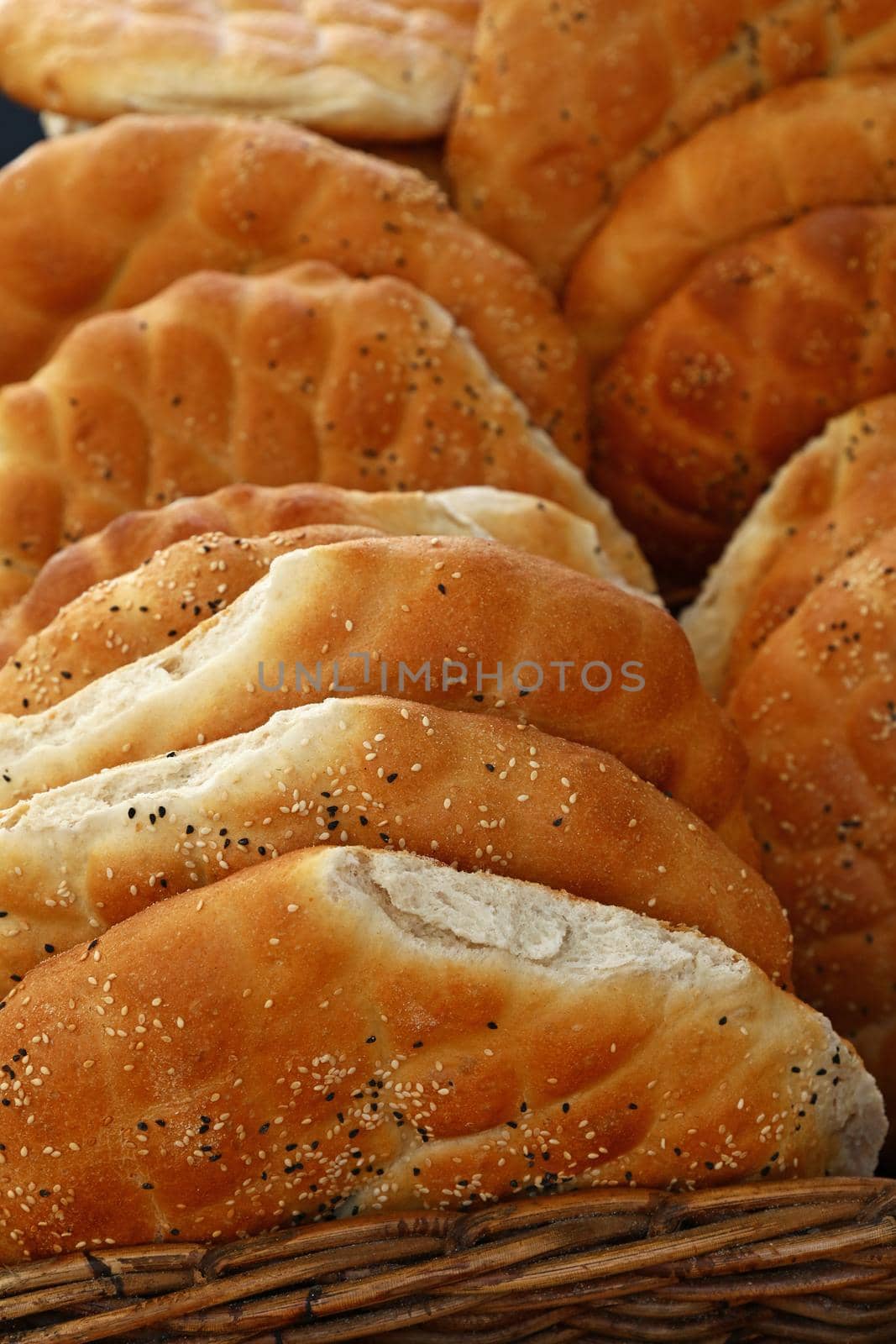 Close up several fresh flatbread loaves on retail display of bakery store, high angle view