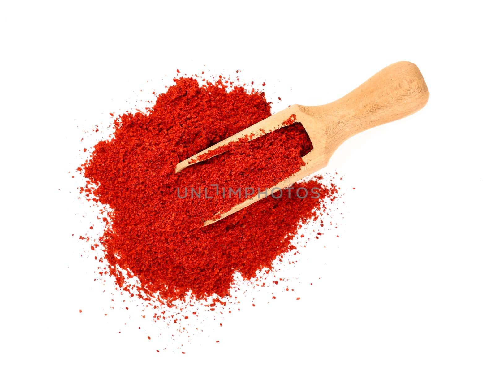 Close up one wooden scoop full of red chili pepper, paprika or sundried tomato powder spilled and spread around isolated on white background, elevated top view, directly above