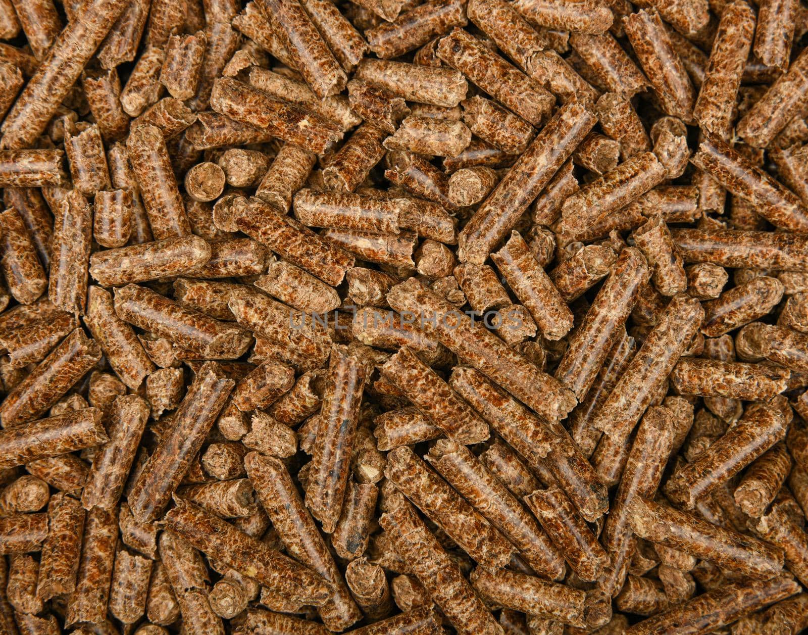 Close up background pattern of hardwood pellets for food smoking and cooking, elevated top view, directly above