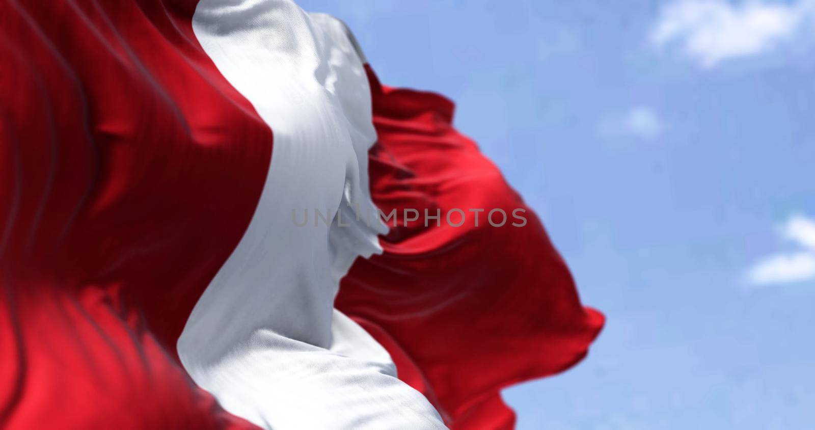 Detail of the national flag of Peru waving in the wind on a clear day. Democracy and politics. South american country. Patriotism. Selective focus.