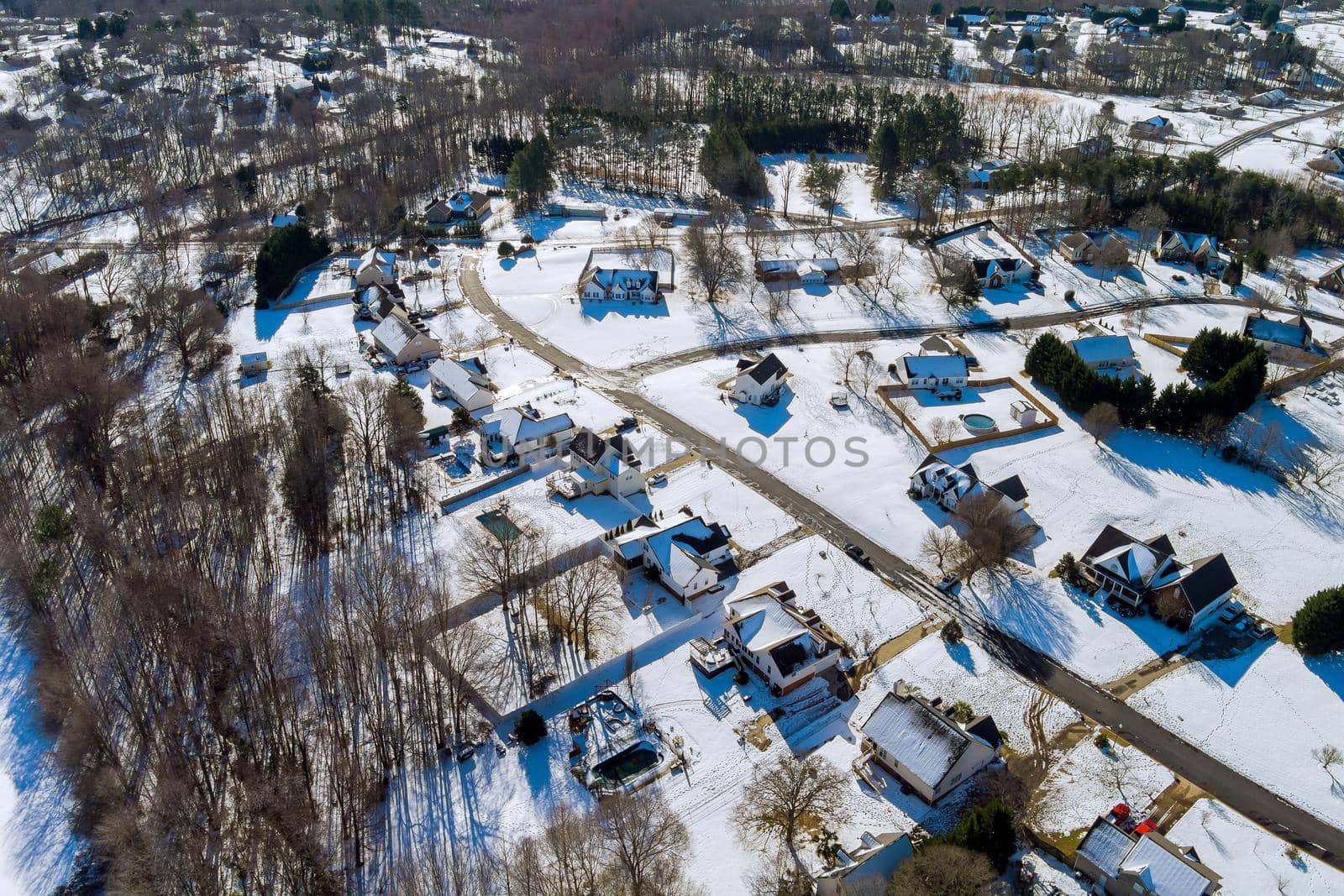 Aerial view of landscape top of the winter town residential houses with snow covered houses and roads. by ungvar