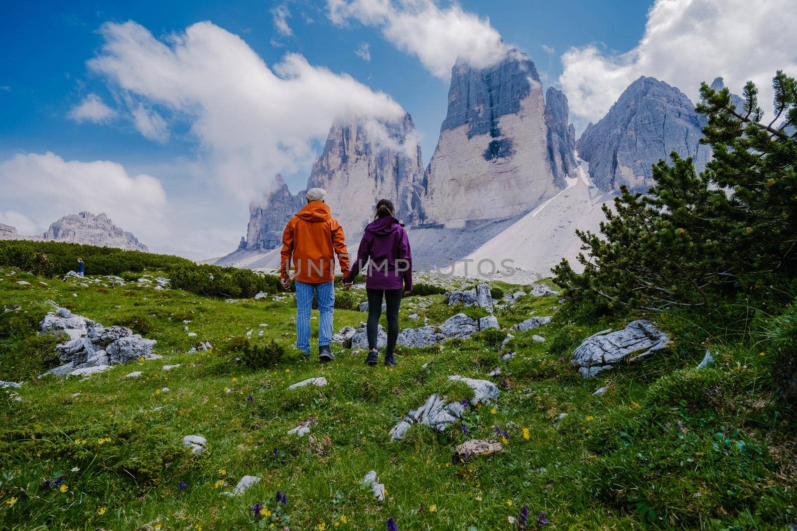 Tre Cime di Lavaredo peaks or Drei Zinnen at sunset, Dobbiaco Toblach, Trentino -Alto Adige or South Tyrol, Italy. Europe Alps. couple man and woman hiking in the Dolomites