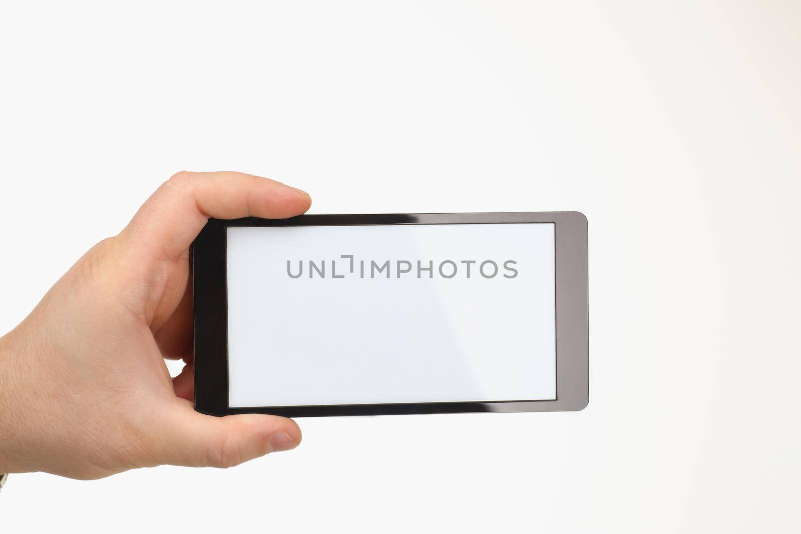 Close-up of person hold smartphone with white screen on white background. Mobile phone doesnt work, useless device. Mockup, technology concept. Copy space