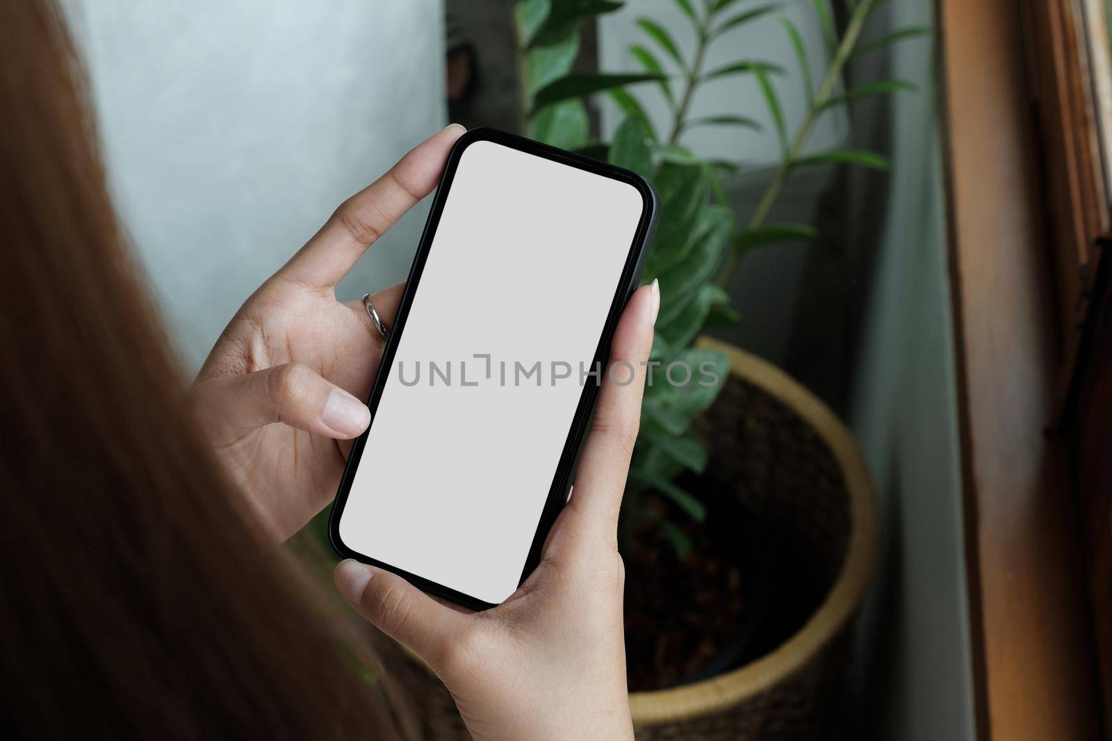 cell phone blank white screen mockup.woman hand holding texting using mobile on desk at office.background empty space for advertise.