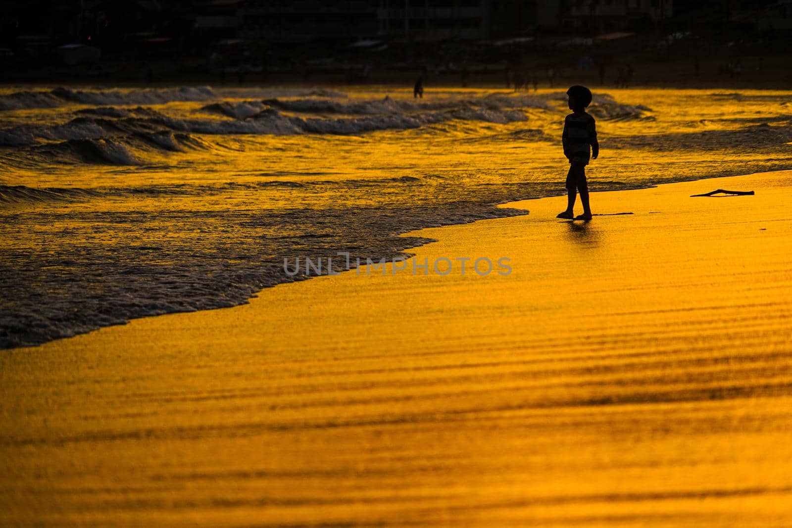 Kid playing at dusk waves. Shooting Location: Kamakura City, Kanagawa Prefecture