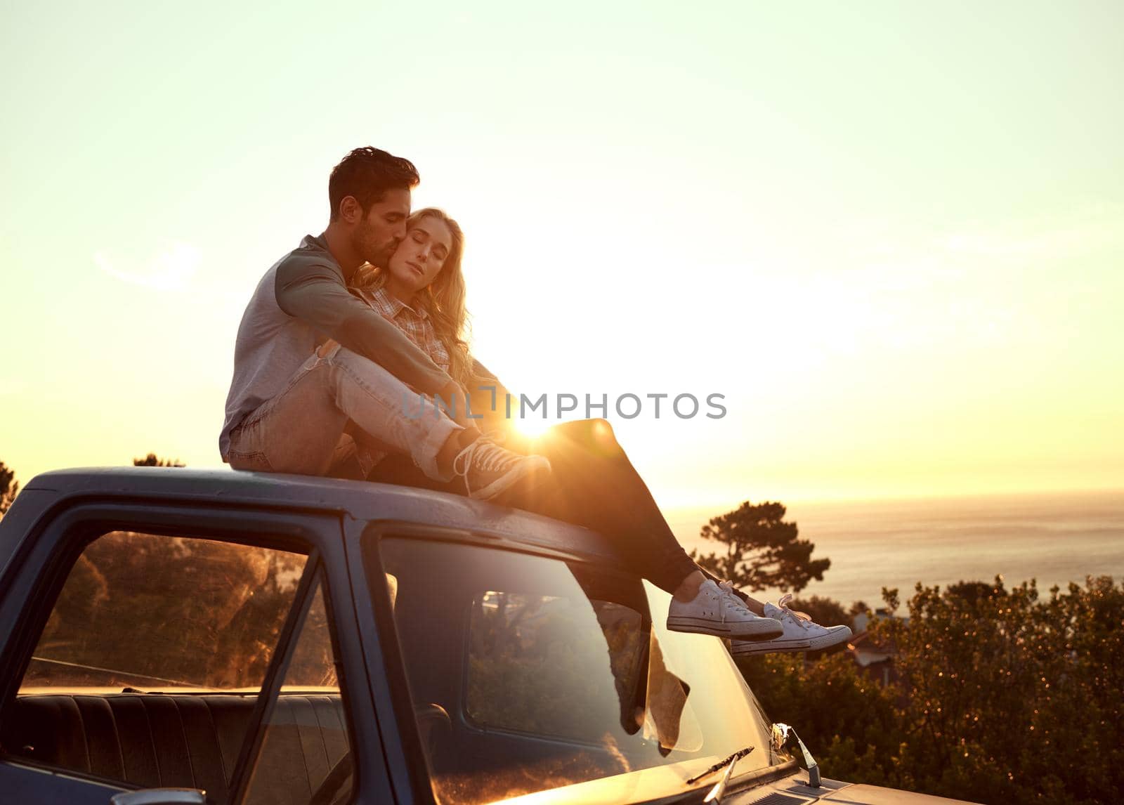 Romance on the road. Shot of an affectionate young couple enjoying a roadtrip together. by YuriArcurs