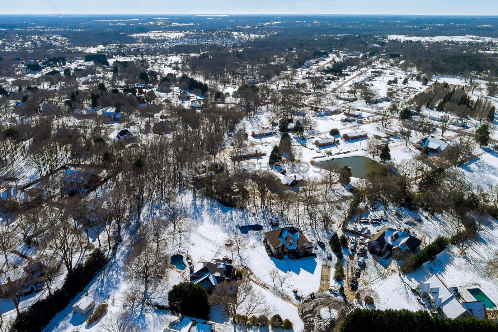 Aerial view of snowed in traditional housing estate the suburbs in dangerous weather conditions by ungvar
