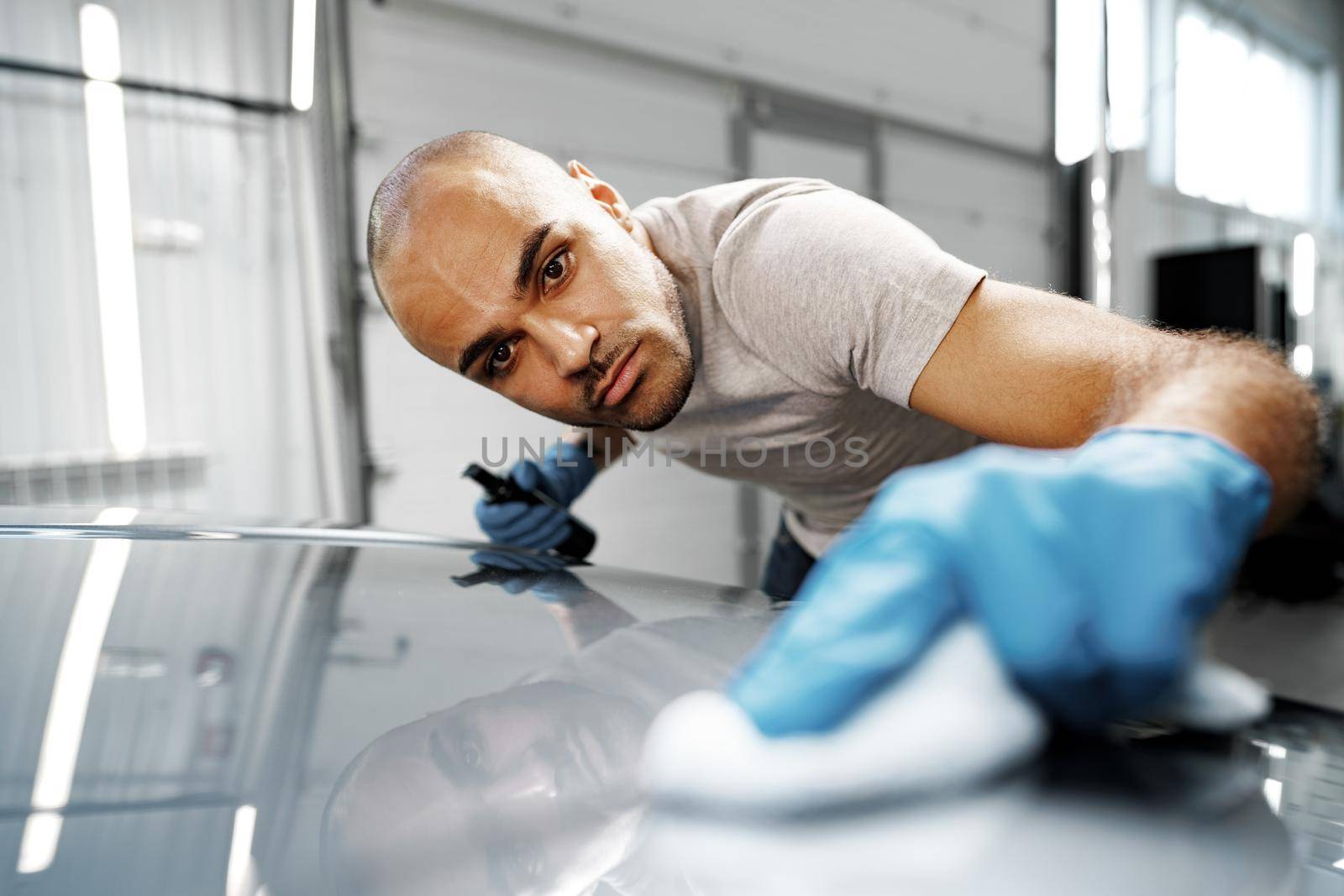 African American man car service worker applying nano coating on a car, close up