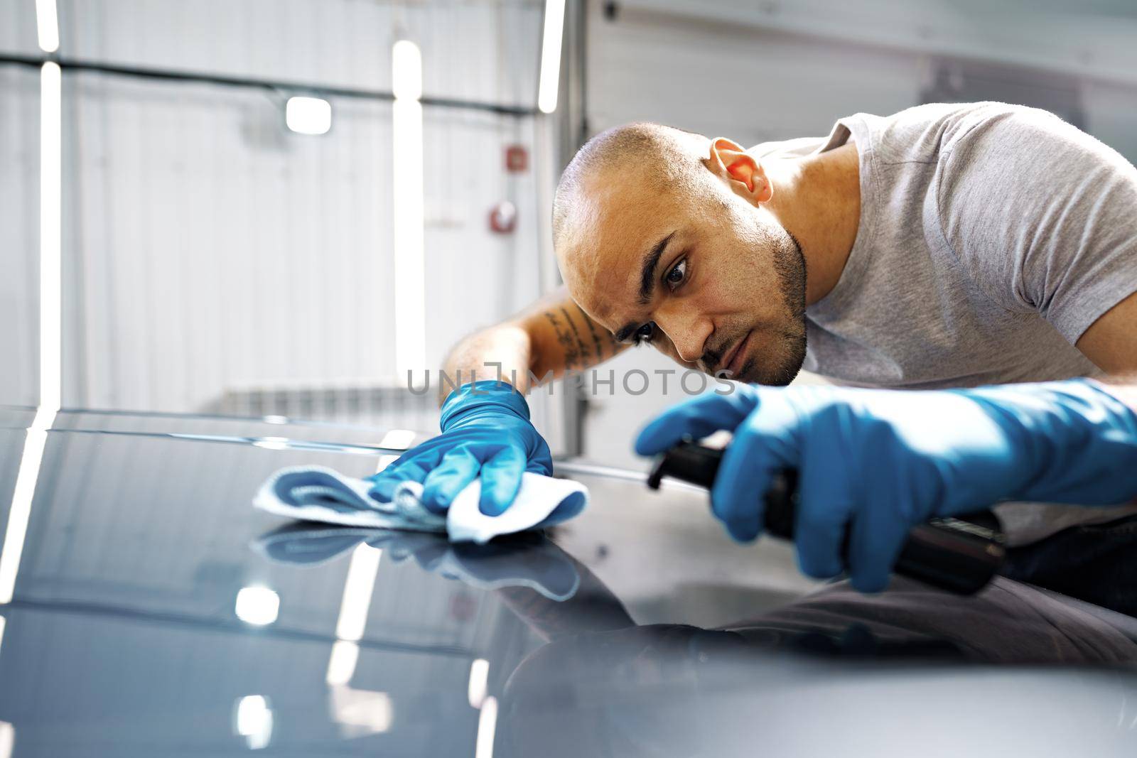 African American man car service worker applying nano coating on a car, close up