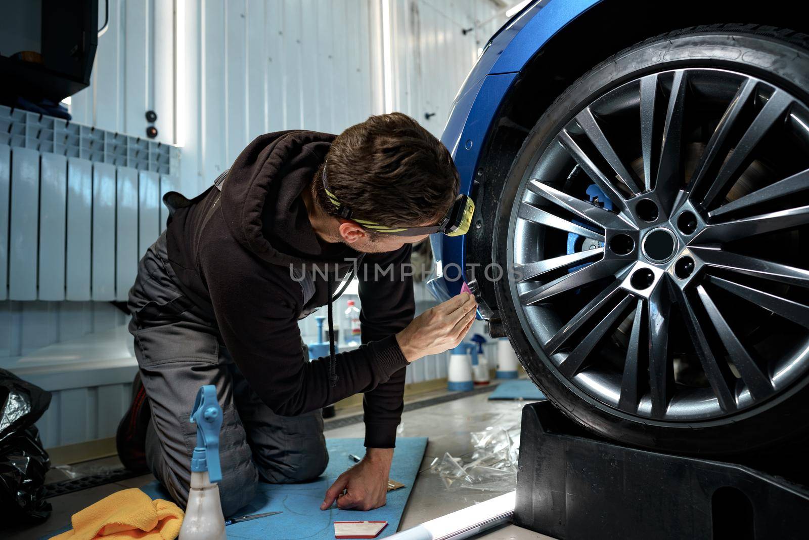 Car detailing. Man applies nano protective coating to the car in car detailing service, close up