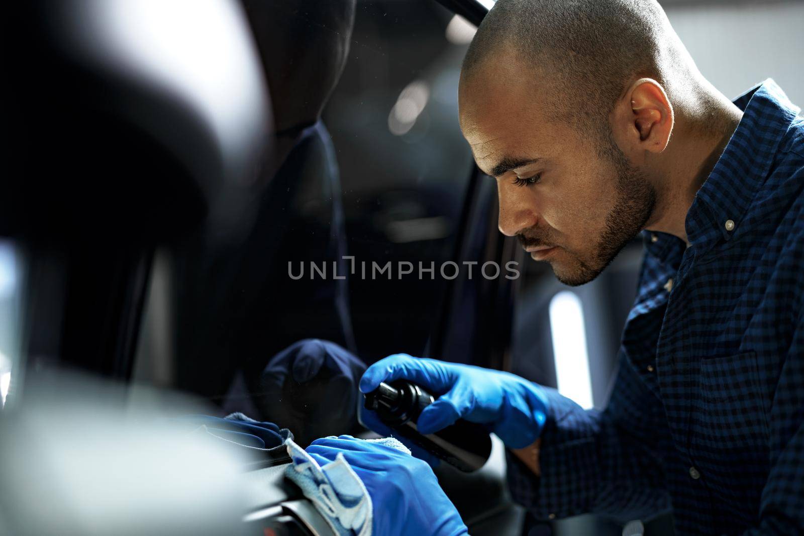 African American man car service worker applying nano coating on a car, close up