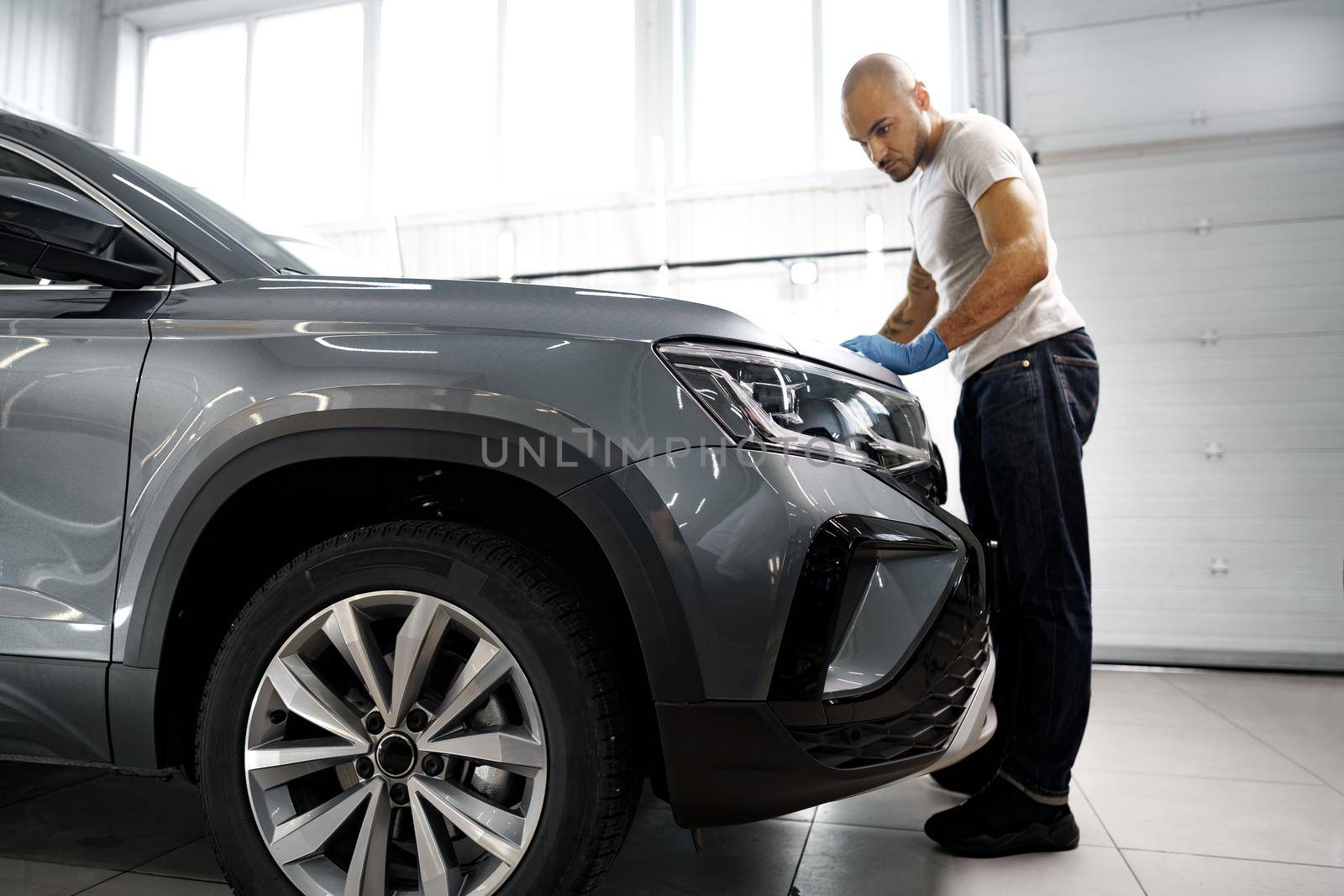 African American man car service worker applying nano coating on a car, close up