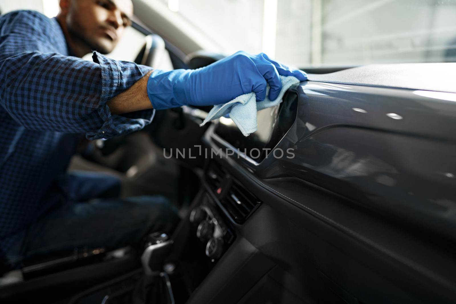 A man cleaning car interior, car detailing in Carwash service, close up