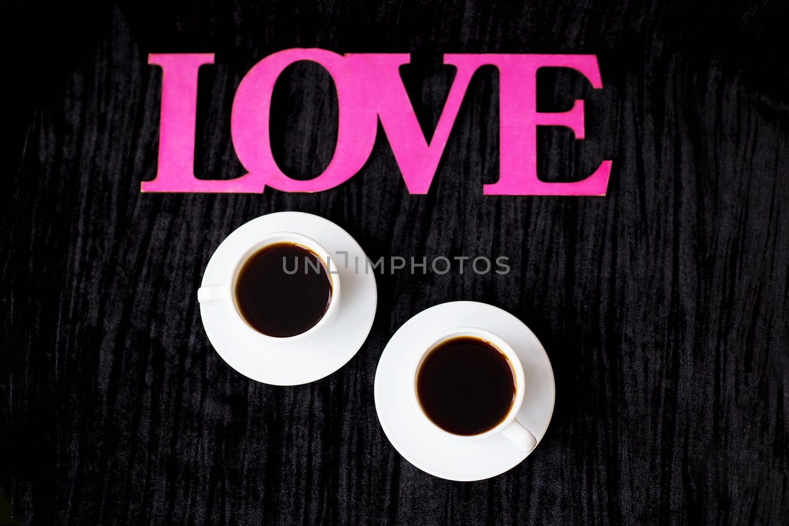 two cups of coffee on pink background inscription love Valentine's Day.