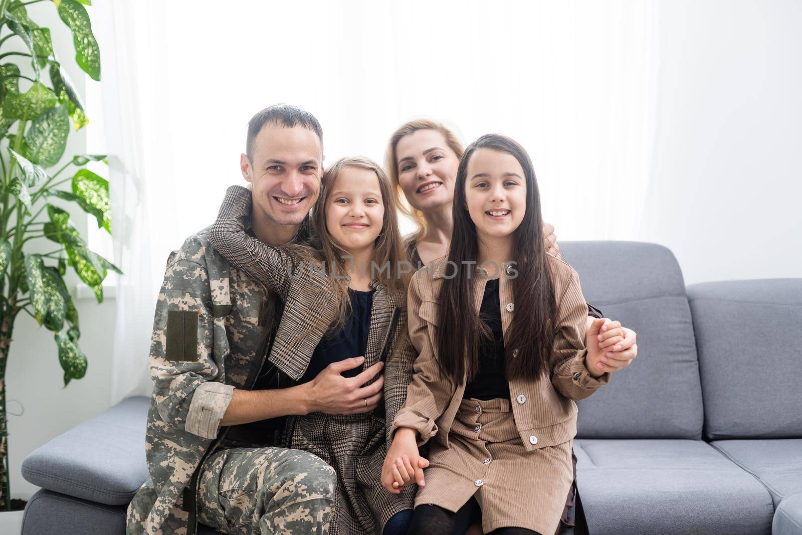 Military father with his family on sofa at home.