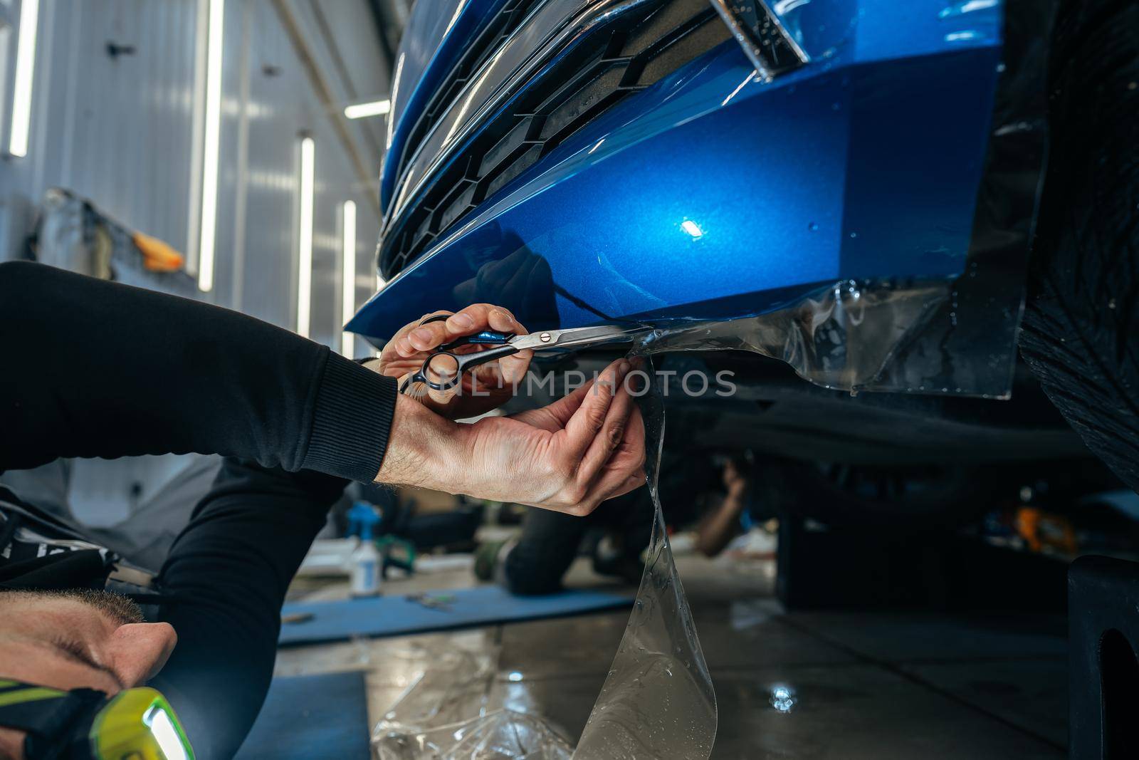 Car detailing. Man applies nano protective coating to the car in car detailing service, close up