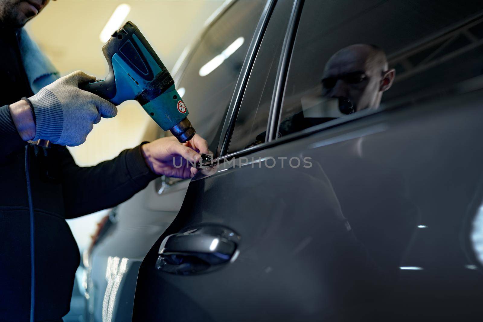 Close up photo of male car service worker applying nano coating on a car