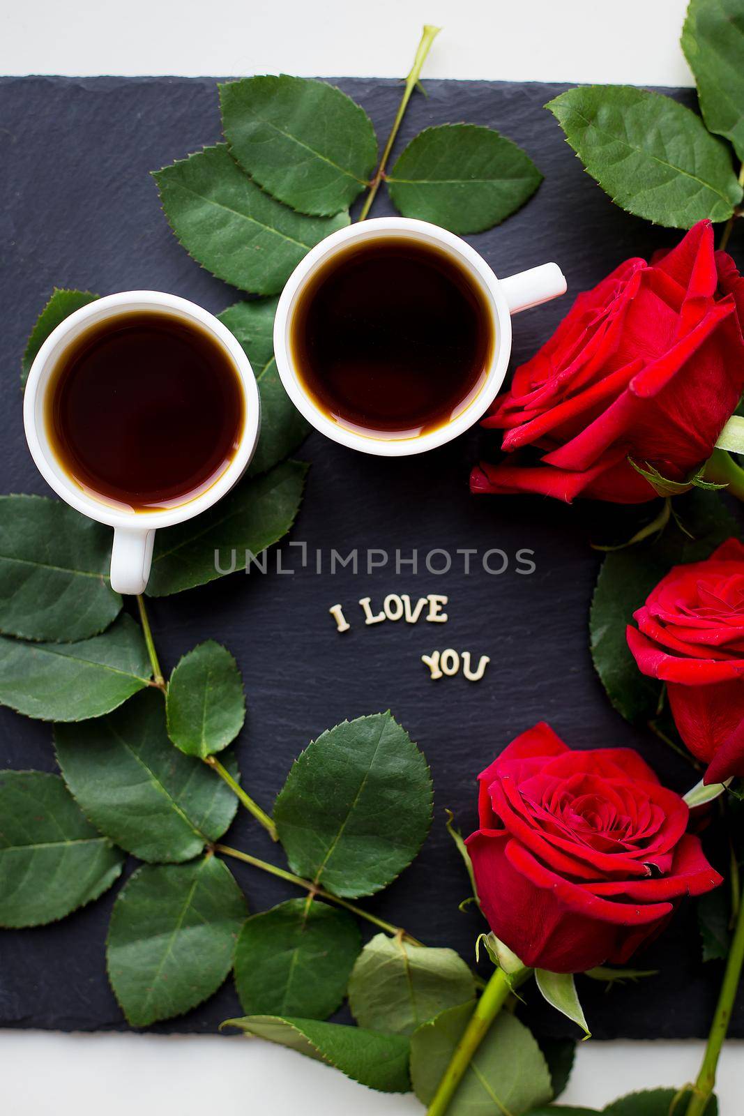 The inscription I love you on a black background, coffee, red roses