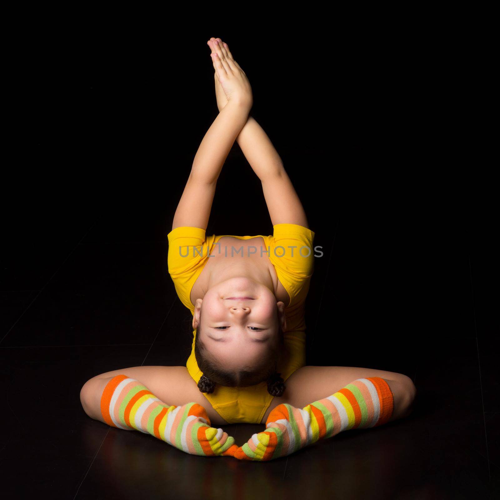 Cute flexible little girl acrobat do acrobatic exercise by kolesnikov_studio