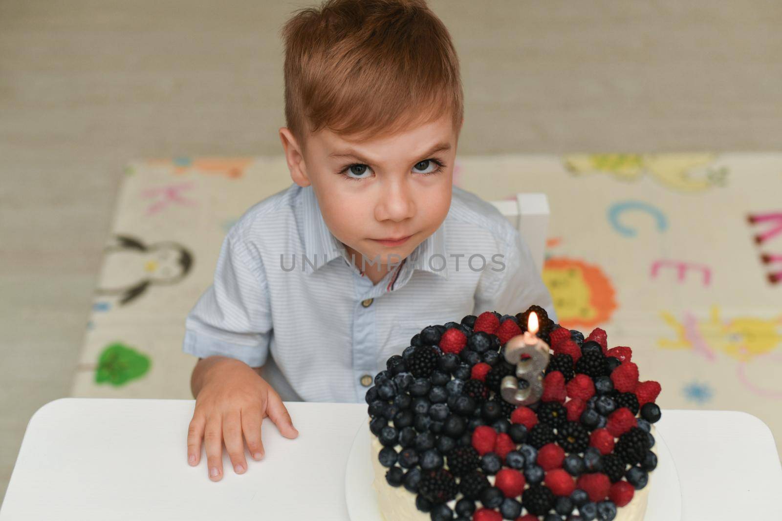 Boy blows out the candles for his birthday by Godi