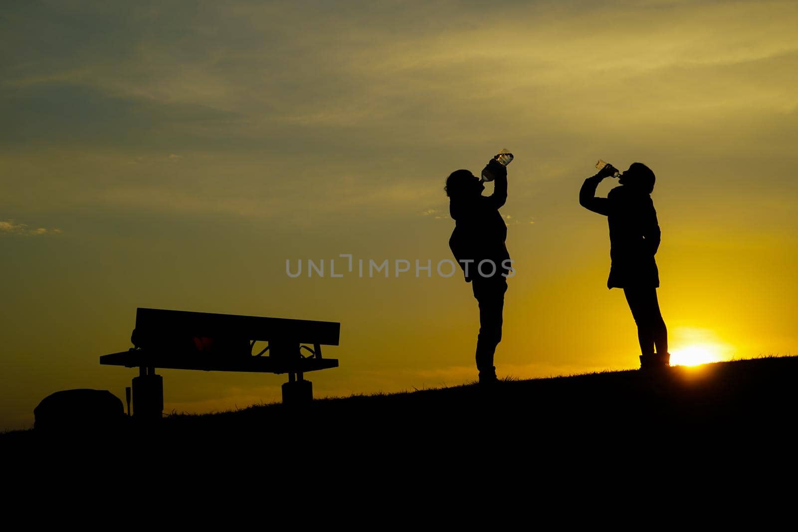 Men and women drinking water on the hill at dusk. Shooting Location: Tokyo metropolitan area
