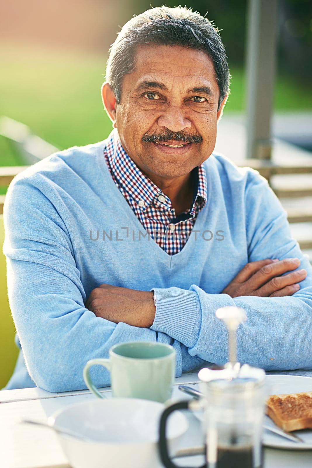 Portrait of an older man having his breakfast outdoors